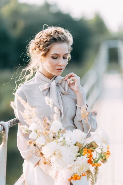 花や装飾と結婚式のアーチの前で美しい花嫁 手に花束と詳細 女の子は 笑顔と踊り満足しています 現代風の夢のウェディングドレス — ストック写真