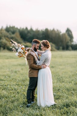 Düğün Amerikan tarzı, bir at ile bir çiftlikte. Çiftler batımında, arkadaş grubu ve sırtında tarlada yürümek. Modern çift ve tören için fikirler.