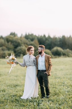 Düğün Amerikan tarzı, bir at ile bir çiftlikte. Çiftler batımında, arkadaş grubu ve sırtında tarlada yürümek. Modern çift ve tören için fikirler.