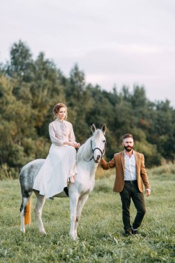Düğün Amerikan tarzı, bir at ile bir çiftlikte. Çiftler batımında, arkadaş grubu ve sırtında tarlada yürümek. Modern çift ve tören için fikirler.