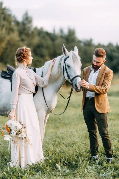 Wedding in American style, on a ranch with a horse. Walk couples in the fields at sunset, with friends and on horseback. Modern couple and ideas for the ceremony.