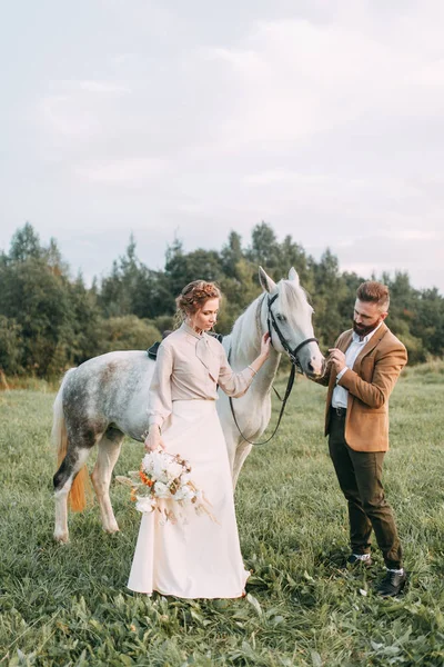 Wedding in American style, on a ranch with a horse. Walk couples in the fields at sunset, with friends and on horseback. Modern couple and ideas for the ceremony.