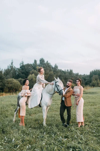馬と牧場のアメリカン スタイルの結婚式 友人とは馬に乗って 夕暮れ時のカップルのフィールドで歩いてください モダンなカップルは 式のためのアイデア — ストック写真