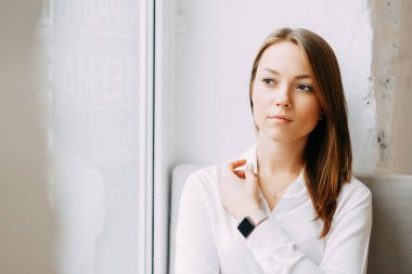 Oturma ve çalışma bir kafede kahve ile genç blogger kız. Kahve Dükkanı, gülümsüyor ve gözleri mutlu parlak portre. İş kadını, sıkı stili