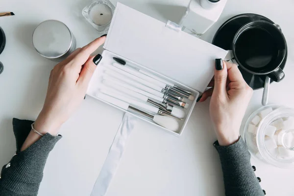 Brush brow and makeup artist in the set. Black and white sets. Flatley layout for blogger. Minimalism on the table, gold brushes