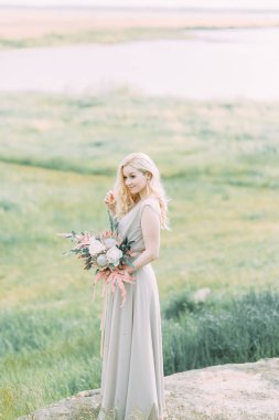 Doğada, dağlarda gelin. Düğün güzel sanatlar tarzında. Dağlar ve boudoir elbiseli günbatımı.