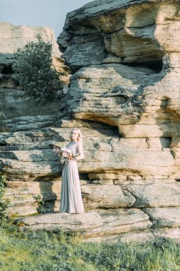 Doğada, dağlarda gelin. Düğün güzel sanatlar tarzında. Dağlar ve boudoir elbiseli günbatımı.
