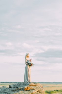 Doğada, dağlarda gelin. Düğün güzel sanatlar tarzında. Dağlar ve boudoir elbiseli günbatımı.