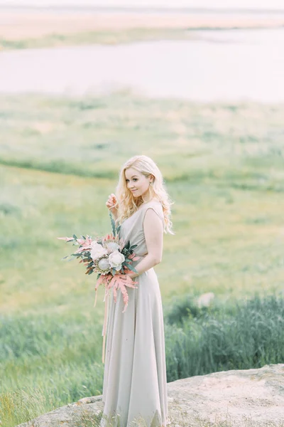 Bride in nature, in the mountains. Wedding in the style of fine art. The mountains and the sunset in the boudoir dress.