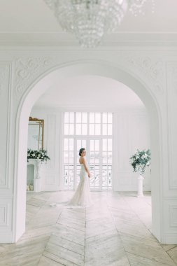 Güzel gelin beyaz bir stüdyoda. St. Petersburg'daki Rus düğün. Portre ve güzel sanatlar stil detayları.