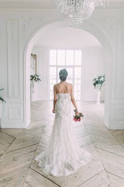 Güzel gelin beyaz bir stüdyoda. St. Petersburg'daki Rus düğün. Portre ve güzel sanatlar stil detayları.