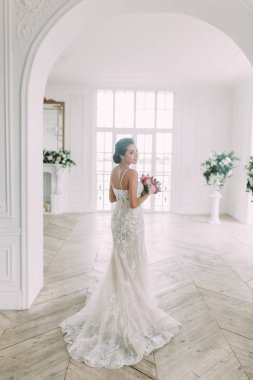 Güzel gelin beyaz bir stüdyoda. St. Petersburg'daki Rus düğün. Portre ve güzel sanatlar stil detayları.