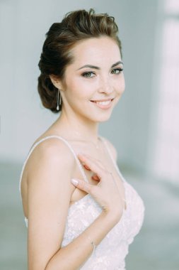 Güzel gelin beyaz bir stüdyoda. St. Petersburg'daki Rus düğün. Portre ve güzel sanatlar stil detayları.