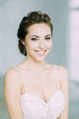 Güzel gelin beyaz bir stüdyoda. St. Petersburg'daki Rus düğün. Portre ve güzel sanatlar stil detayları.