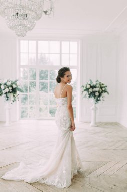 Güzel gelin beyaz bir stüdyoda. St. Petersburg'daki Rus düğün. Portre ve güzel sanatlar stil detayları.