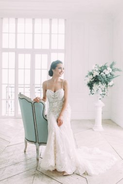 Güzel gelin beyaz bir stüdyoda. St. Petersburg'daki Rus düğün. Portre ve güzel sanatlar stil detayları.