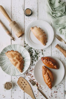 Turta ve ahşap açık renkli üzerinde khachapuri. Gıda styling ve taze malzemelerle pişirme.