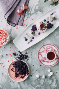 Tatlı çiçek ve kahve masada. Dekor ve tatlılar mor ile Foodstyling.