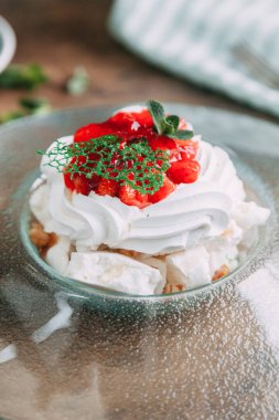 Pavlova tatlı güzel bir kompozisyon içinde çilek ile. Foodstyling kahve ve çilek ahşap bir zemin üzerine.