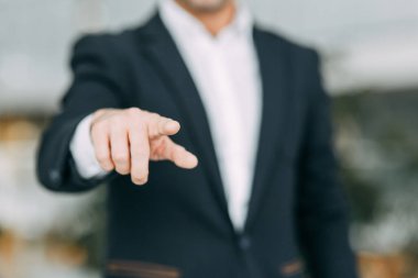 İş adamı parmağını ekrana doğrultur, basar ve vurur. Tasarımcının elinde boşluk.