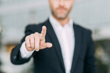 İş adamı parmağını ekrana doğrultur, basar ve vurur. Tasarımcının elinde boşluk.