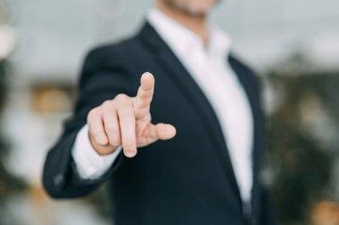 İş adamı parmağını ekrana doğrultur, basar ve vurur. Tasarımcının elinde boşluk.