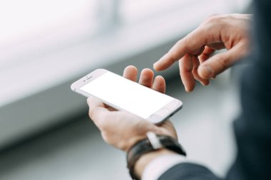 Beyaz bir ekran ile bir iş adamı elinde telefon. Bokeh ile tasarımcılar için boş.