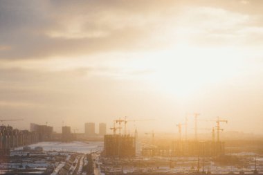 Şafakta bina inşaatı. Arka plan sanayi kenti.