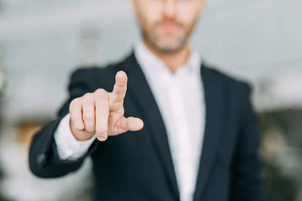 The businessman points his finger at the screen, presses and taps. Blank for the designer to hand.