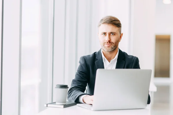 An employee at the laptop, the business aspects. Bright and stylish office interior and cut out the background.