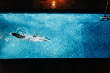 Villa Havuz yüzme bir mayo kız. Gece su altında yüzme.