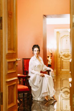 Gelinin ücretleri bir buket ile lüks otel. Gelin boudoir elbiseli sabahlık.