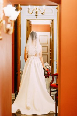 Gelini bir buket ile bir pahalı lüks otel. Merdivenlerde ve koridorda duran.