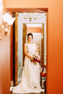 Gelini bir buket ile bir pahalı lüks otel. Merdivenlerde ve koridorda duran.