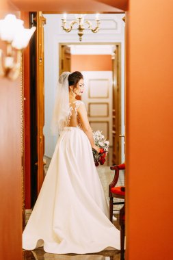 Gelini bir buket ile bir pahalı lüks otel. Merdivenlerde ve koridorda duran.