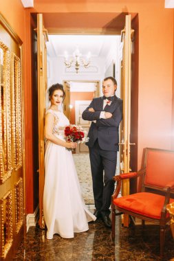 Yeni evliler Studio ve otel toplantı. Gelin ve damat bir buket ile.