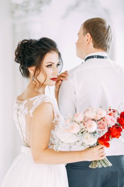 Yeni evliler Studio ve otel toplantı. Gelin ve damat bir buket ile.