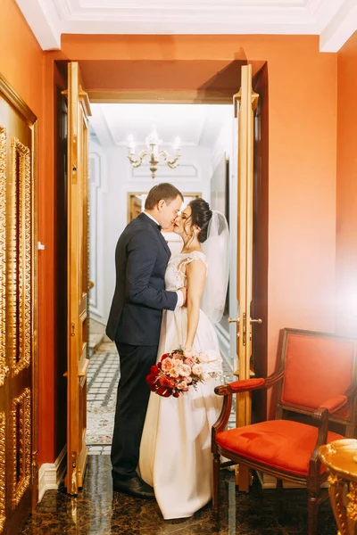 Meeting the newlyweds in the Studio and hotel. Bride and groom with a bouquet.