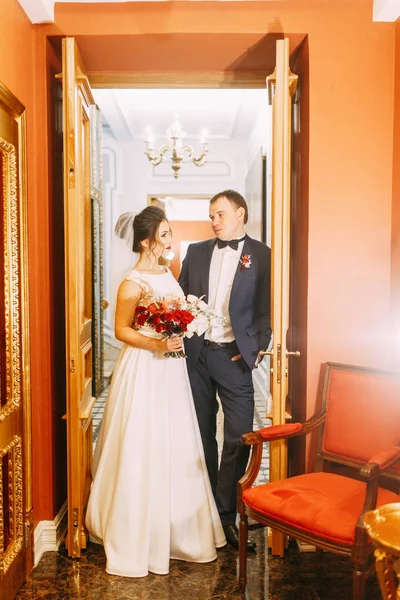 Meeting the newlyweds in the Studio and hotel. Bride and groom with a bouquet.