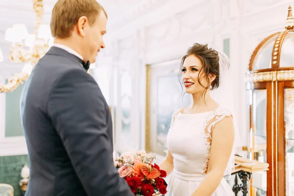 Meeting the newlyweds in the Studio and hotel. Bride and groom with a bouquet.