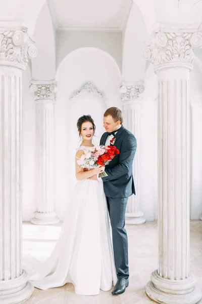 Meeting the newlyweds in the Studio and hotel. Bride and groom with a bouquet.