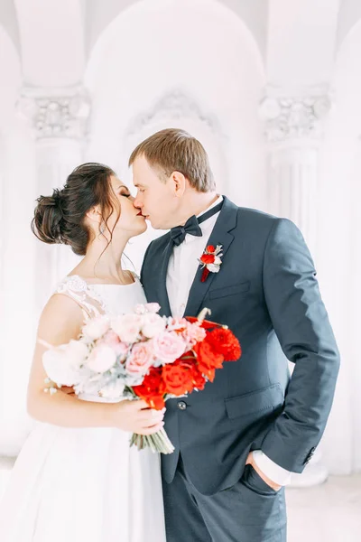 Meeting the newlyweds in the Studio and hotel. Bride and groom with a bouquet.