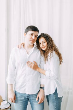 Genç çift, sarılma ve yatağın değil mücadele. Avrupa tarzı parlak iç stüdyo fotoğraf çekimi.