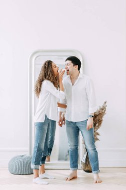 Genç kucaklayan ve bir ayna önünde oturan çift. Avrupa tarzı parlak iç stüdyo fotoğraf çekimi.