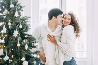 Genç kucaklayan ve bir ayna önünde oturan çift. Avrupa tarzı parlak iç stüdyo fotoğraf çekimi.