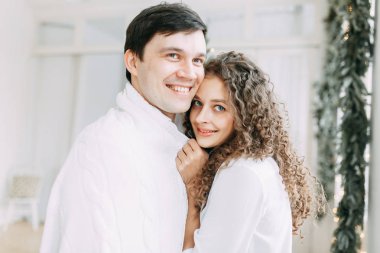 Genç kucaklayan ve bir ayna önünde oturan çift. Avrupa tarzı parlak iç stüdyo fotoğraf çekimi.