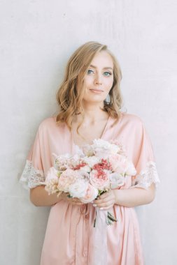 Bir elbise yatakta aydınlık sabah gelin. Avrupa tarzı parlak iç stüdyo fotoğraf çekimi.