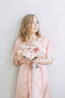 Bir elbise yatakta aydınlık sabah gelin. Avrupa tarzı parlak iç stüdyo fotoğraf çekimi.