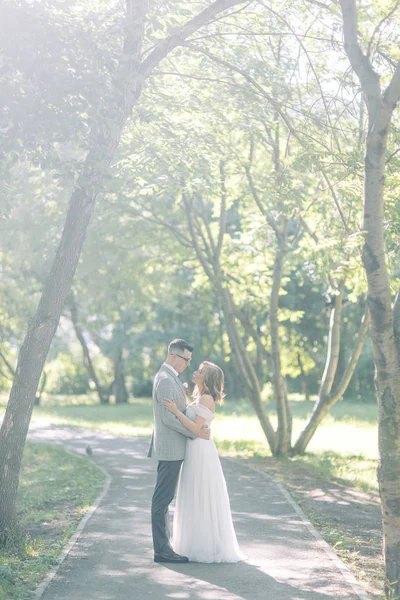 Wedding couple in the Park hugging and kissing. Photo shoot in the style of fine art in nature.
