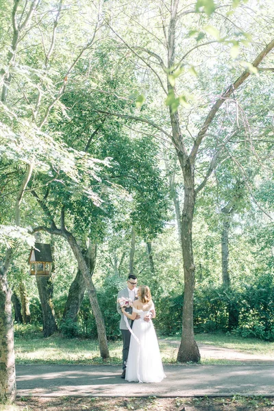 抱き合ったりキスしたり公園での結婚式 自然の中の美術のスタイルで写真撮影 — ストック写真